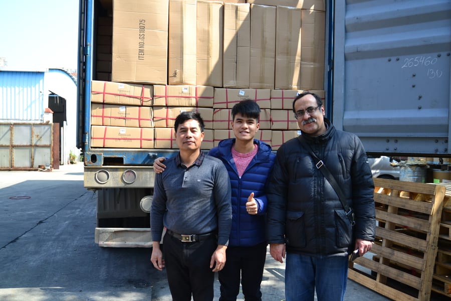 Clients posing in front of loaded container